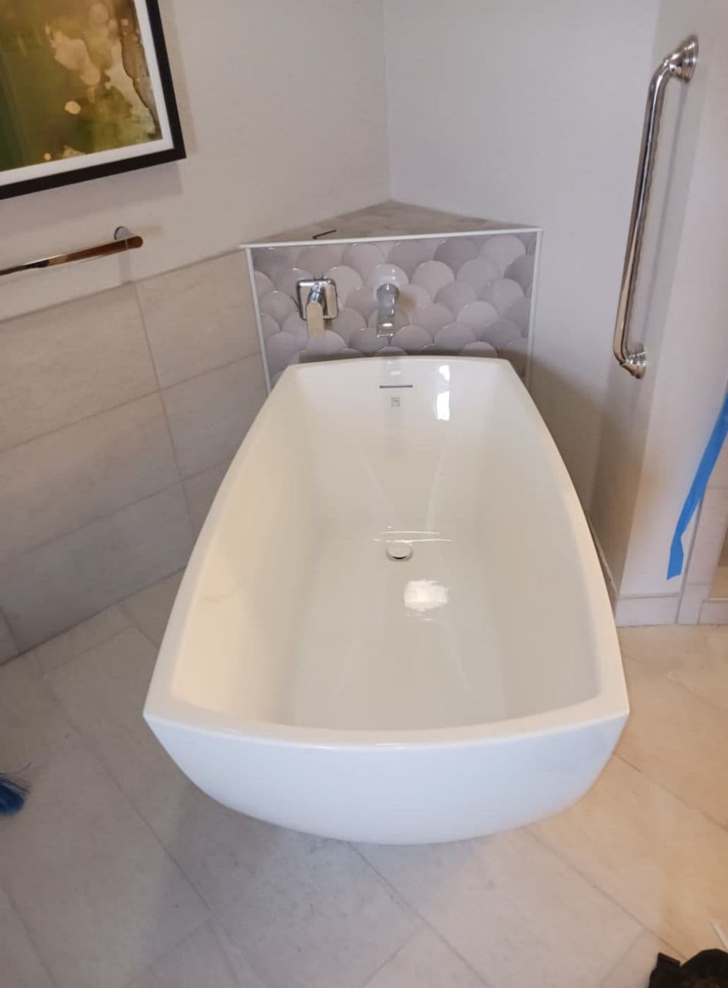 Freestanding soaking tub with scalloped feature tile