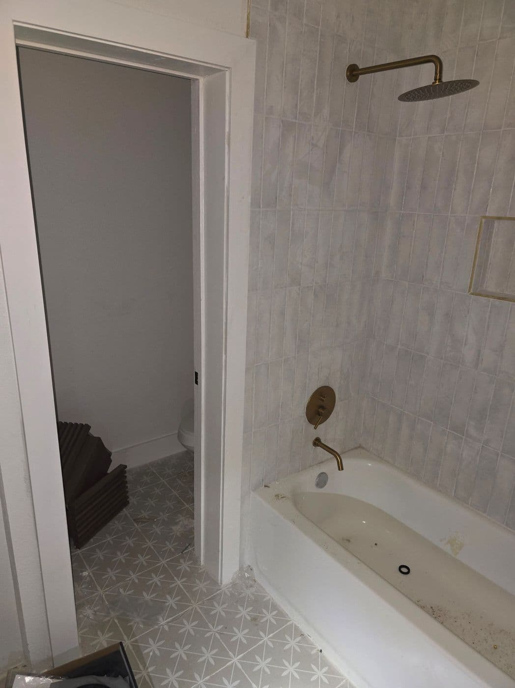 Marble tub and shower combination with brushed-brass fixtures